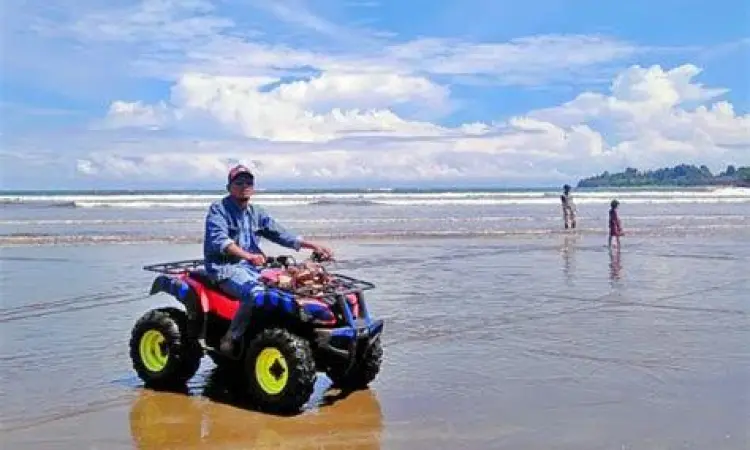 pengunjung bermain atv di pantai air manis