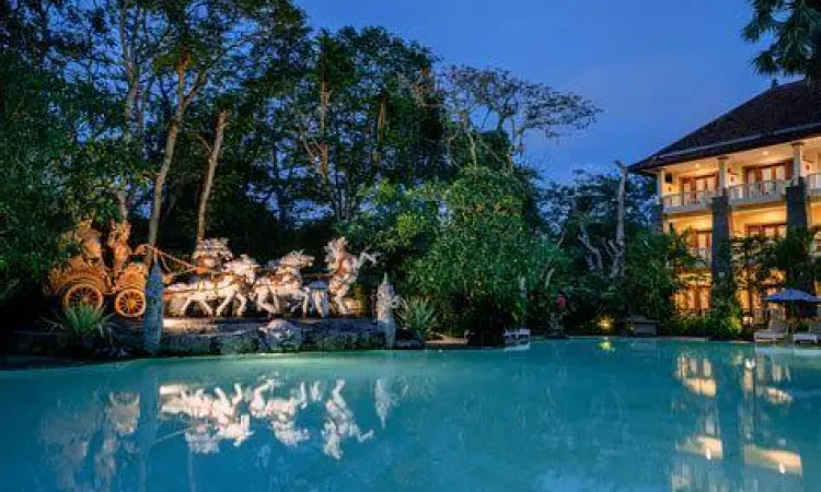 Kolam renang luar ruangan Hotel Kumala Pantai yang dikelilingi taman tropis