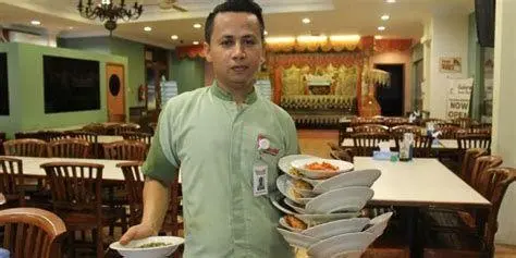 Atraksi Pelayan Padang Pelayan membawa banyak piring nasi padang